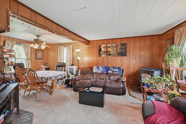 383 Main St, Pittsfield, ME 04967 - living room featuring a wood stove, carpet floors, wooden walls, and ceiling fan