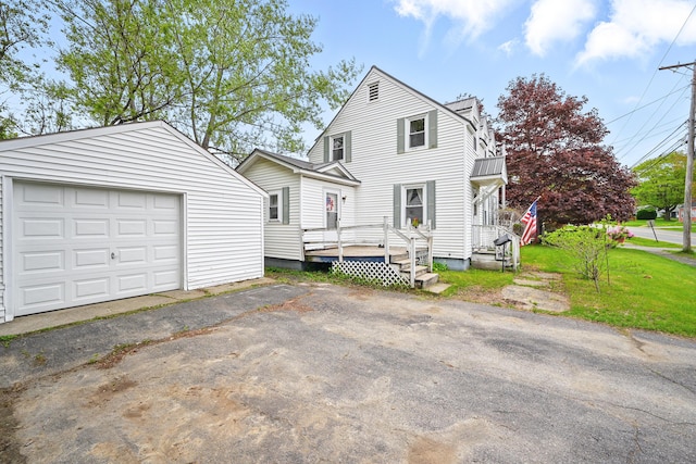 383 Main St, Pittsfield, ME 04967 - view of front of house featuring an outdoor structure, asphalt driveway, a detached garage, and a wooden deck