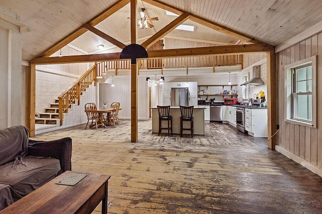 16 Trillium Ests, Rome, ME 04963 - living room with dark wood-type flooring, wooden walls, stairs, and a ceiling fan