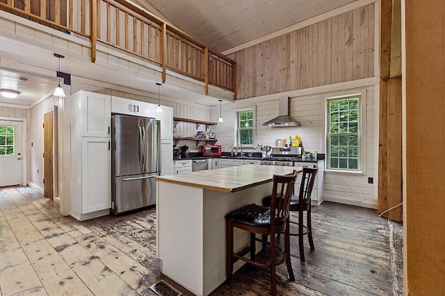16 Trillium Ests, Rome, ME 04963 - kitchen with stainless steel appliances, hardwood / wood-style floors, wall chimney range hood, wood counters, and a sink