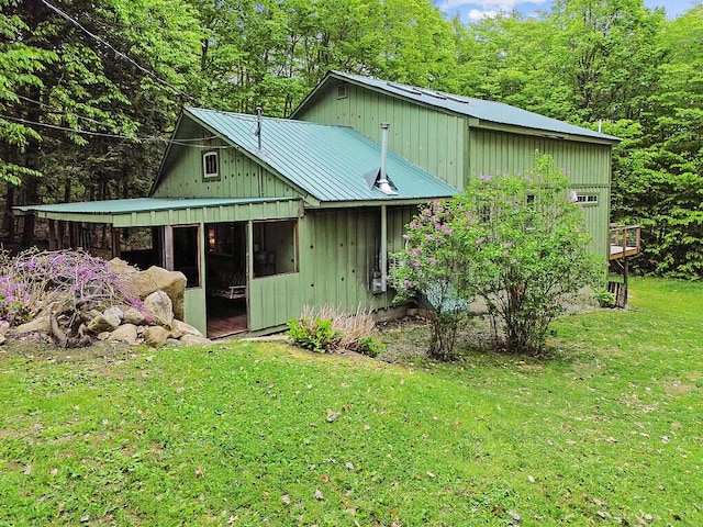 16 Trillium Ests, Rome, ME 04963 - view of side of property with metal roof, a lawn, board and batten siding, and a wooded view