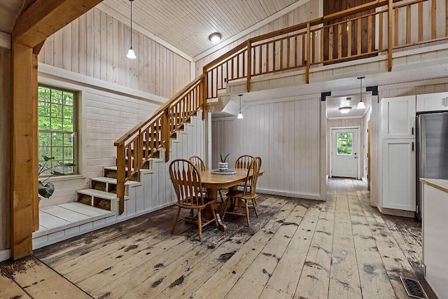 16 Trillium Ests, Rome, ME 04963 - dining space with stairs, hardwood / wood-style floors, wood walls, high vaulted ceiling, and wood ceiling