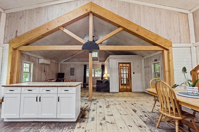 16 Trillium Ests, Rome, ME 04963 - kitchen with wood counters, wooden walls, light wood-style floors, a wall unit AC, and white cabinets