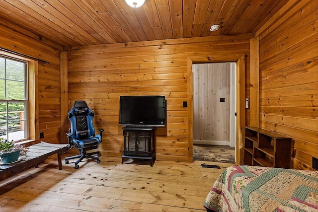 16 Trillium Ests, Rome, ME 04963 - bedroom with wood-type flooring, wooden walls, wooden ceiling, and a wood stove