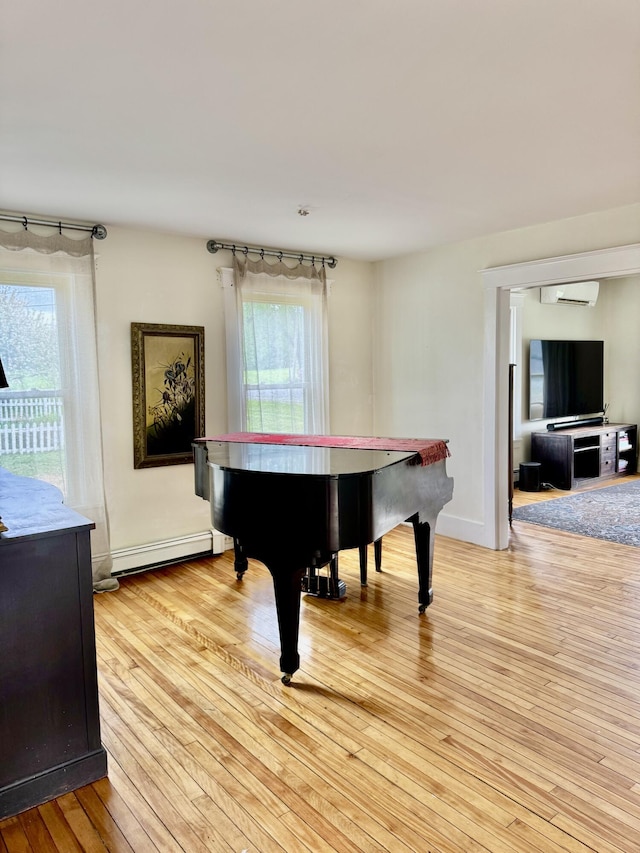 1 Forest St, Dover-Foxcroft, ME 04426 - recreation room featuring baseboard heating, light wood-type flooring, plenty of natural light, and an AC wall unit