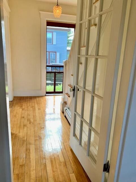 1 Forest St, Dover-Foxcroft, ME 04426 - corridor featuring light wood-style flooring, a baseboard radiator, and stairs