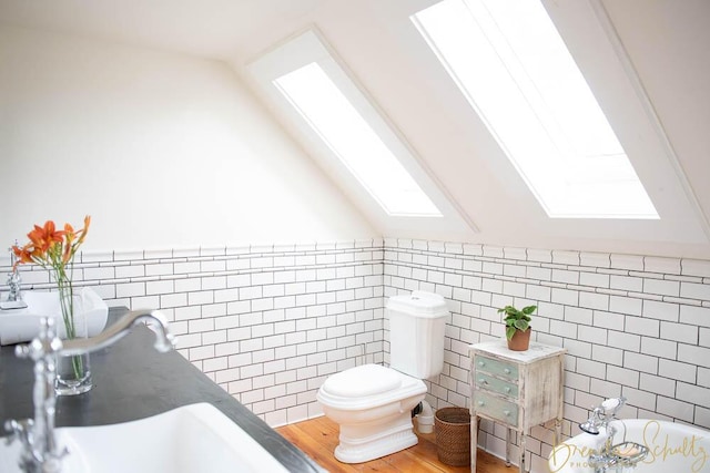 1 Forest St, Dover-Foxcroft, ME 04426 - full bath with a skylight, a tub to relax in, lofted ceiling, tile walls, and wainscoting