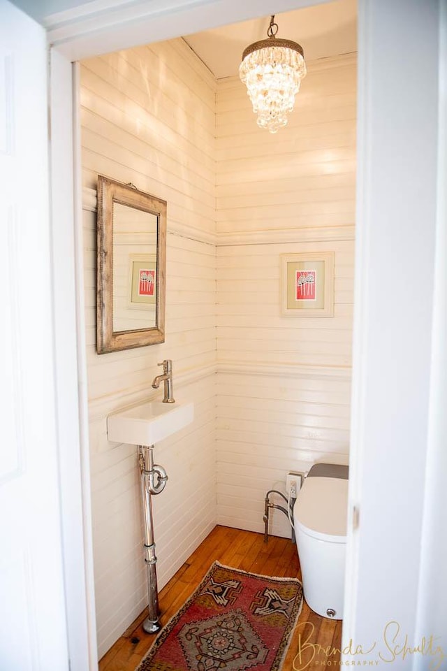 1 Forest St, Dover-Foxcroft, ME 04426 - bathroom featuring wood finished floors, a chandelier, and wooden walls