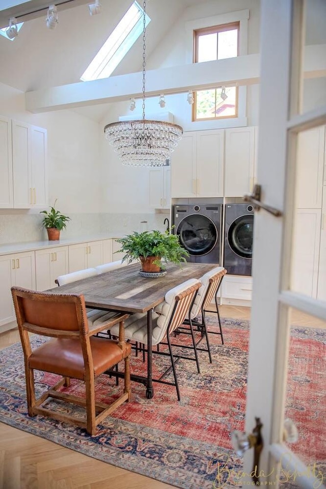 1 Forest St, Dover-Foxcroft, ME 04426 - dining space featuring washer and dryer, a chandelier, high vaulted ceiling, and a skylight