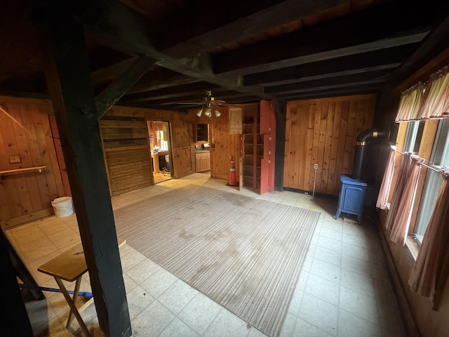 15 Sawyer Ln, Sanford, ME 04083 - spare room featuring wooden walls, a wood stove, light flooring, and a ceiling fan