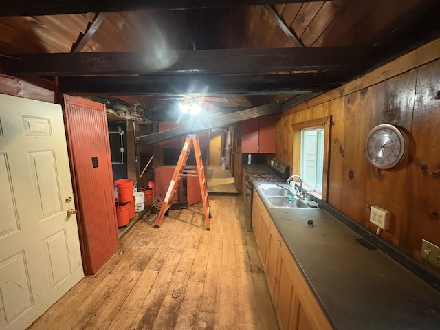 15 Sawyer Ln, Sanford, ME 04083 - kitchen featuring a sink, light wood finished floors, wood walls, stainless steel gas range oven, and dark countertops