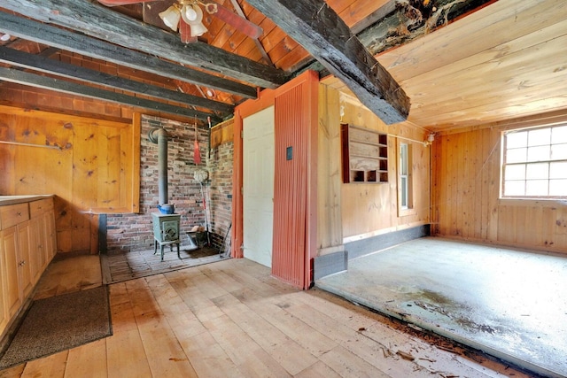 15 Sawyer Ln, Sanford, ME 04083 - empty room with wooden ceiling with exposed beams, hardwood / wood-style flooring, a wood stove, and wooden walls