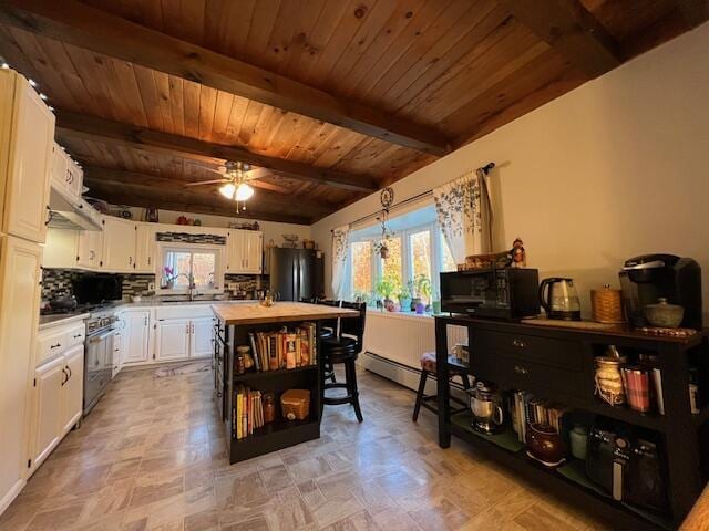 186 Clark Rd, Albion, ME 04910 - kitchen with freestanding refrigerator, black microwave, plenty of natural light, wood ceiling with exposed beams, and white cabinets