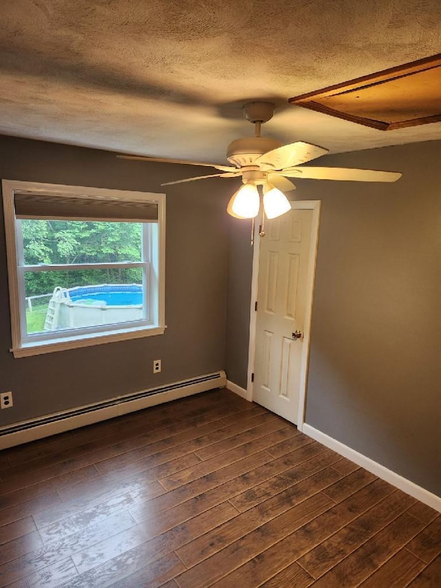 186 Clark Rd, Albion, ME 04910 - spare room with a baseboard heating unit, a textured ceiling, dark wood-style floors, ceiling fan, and baseboards