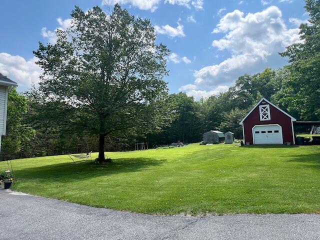 186 Clark Rd, Albion, ME 04910 - view of grassy yard with a detached garage, an outbuilding, a barn, and driveway