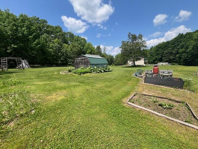 186 Clark Rd, Albion, ME 04910 - view of green lawn featuring a garden and a storage unit