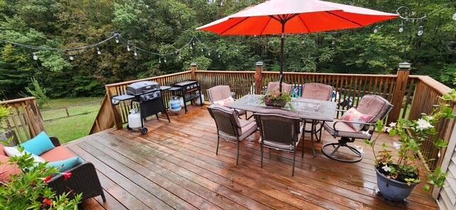 186 Clark Rd, Albion, ME 04910 - wooden terrace featuring outdoor dining area, a grill, and a view of trees