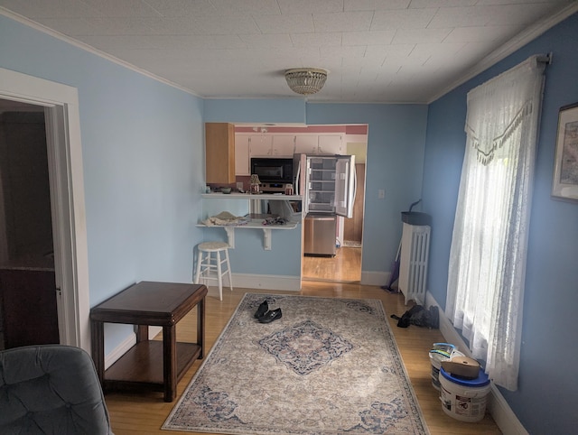 35 Brimmer St, Brewer, ME 04412 - kitchen with black microwave, crown molding, light wood-style flooring, a peninsula, and baseboards