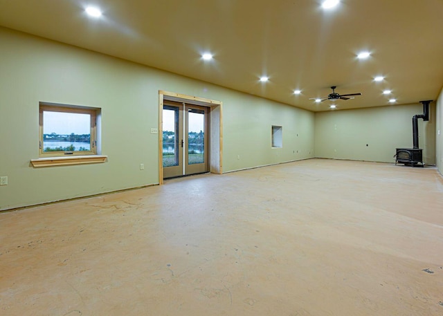 55 Diamond Point Rd, Lubec, ME 04652 - unfurnished living room featuring a wood stove, recessed lighting, concrete floors, a ceiling fan, and french doors