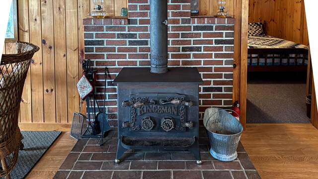 369 Narrow Gauge Trl, Hiram, ME 04041 - detailed view of a wood stove, wood walls, and wood finished floors