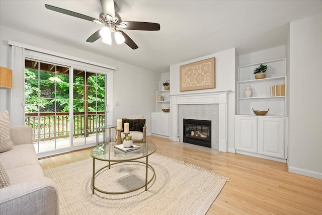 14 Woodside Dr Unit 3, Gorham, ME 04038 - living room featuring wood finished floors, a tiled fireplace, and a ceiling fan