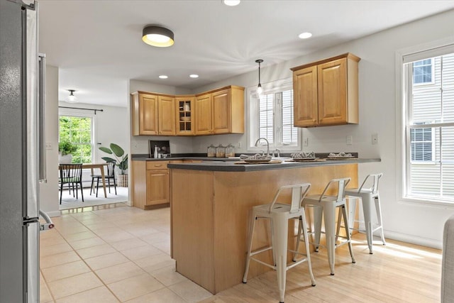 14 Woodside Dr Unit 3, Gorham, ME 04038 - kitchen featuring dark countertops, freestanding refrigerator, a breakfast bar, glass insert cabinets, and a peninsula