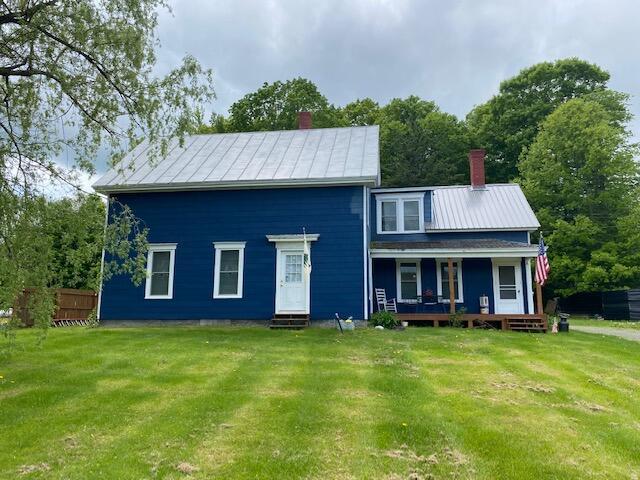 58 Main St, Sangerville, ME 04479 - view of front of home featuring a chimney, entry steps, a front yard, and a standing seam roof