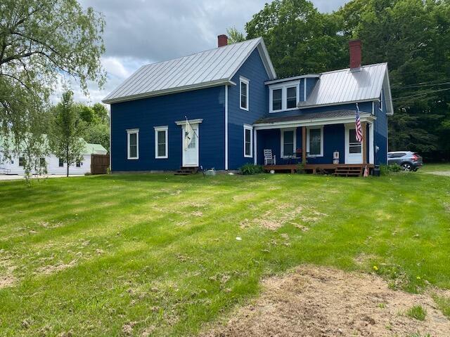 58 Main St, Sangerville, ME 04479 - view of front of house featuring a chimney, a porch, a front lawn, and entry steps