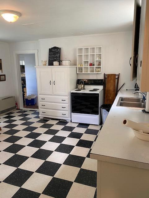58 Main St, Sangerville, ME 04479 - kitchen with white range with electric cooktop, a sink, light flooring, and white cabinets