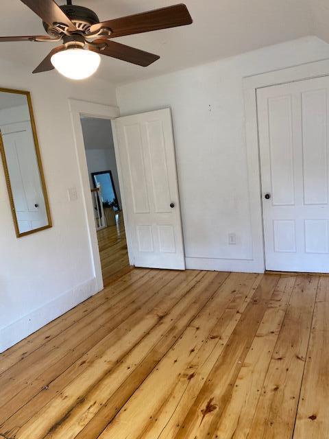 58 Main St, Sangerville, ME 04479 - unfurnished bedroom with light wood-style floors, baseboards, and a ceiling fan