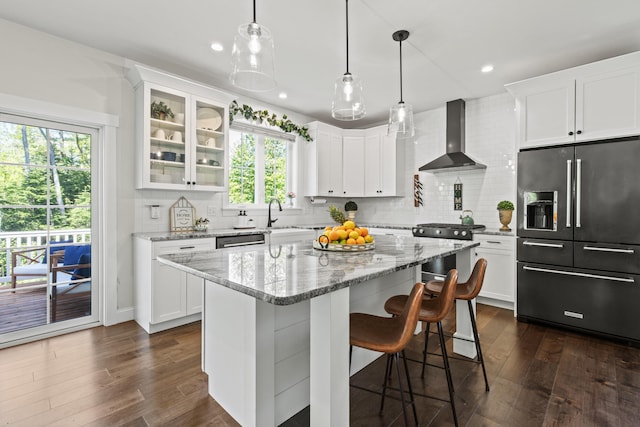 66 Old Dynamite Way, Gorham, ME 04038 - kitchen featuring appliances with stainless steel finishes, wall chimney range hood, glass insert cabinets, decorative backsplash, and white cabinetry