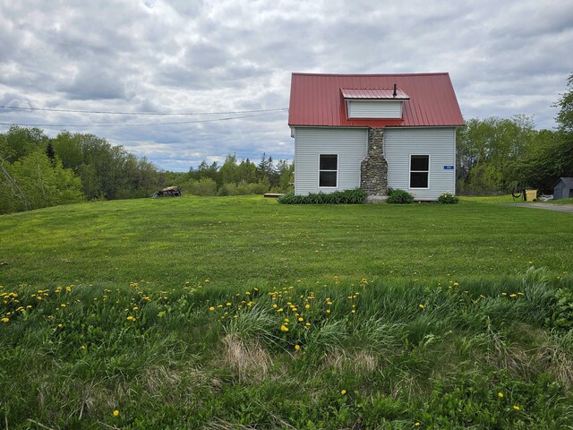 393 Main St, Limestone, ME 04750 - view of side of home featuring a yard and metal roof