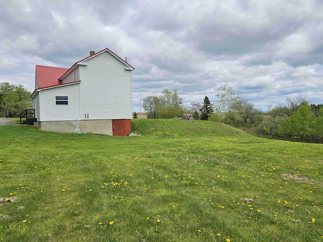 393 Main St, Limestone, ME 04750 - view of property exterior featuring a lawn, a chimney, and metal roof