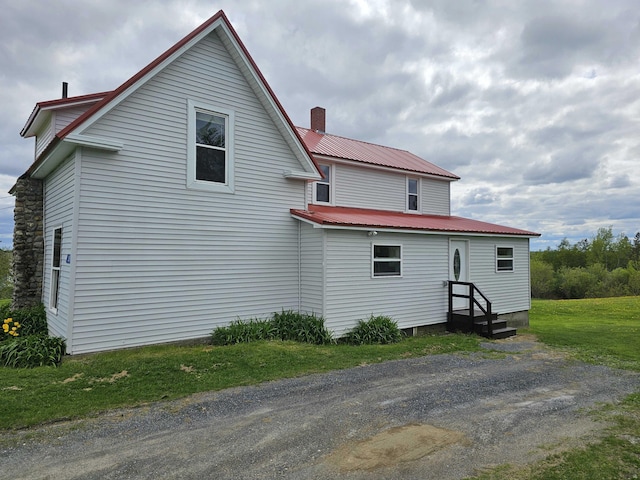 393 Main St, Limestone, ME 04750 - view of home's exterior featuring metal roof and a chimney