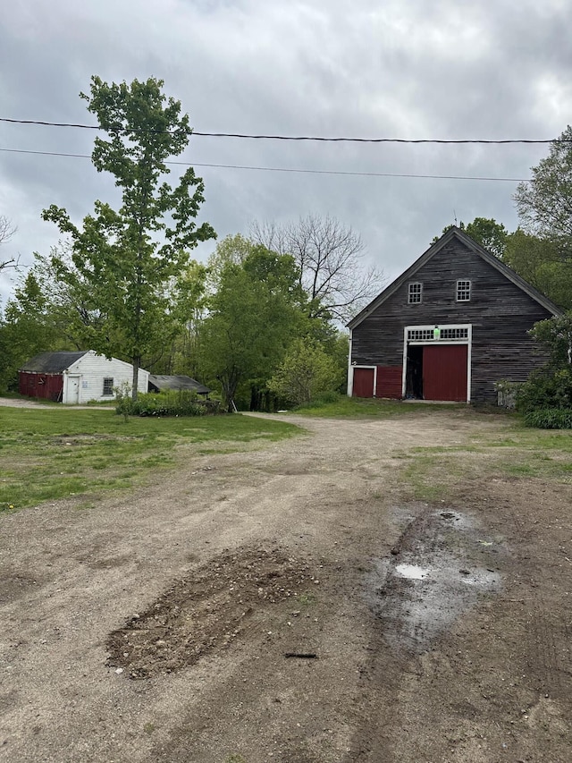 210 Ferguson Rd, Shapleigh, ME 04076 - view of yard featuring a detached garage, driveway, an outdoor structure, and a pole building