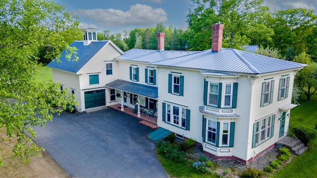 34 Mcphetres Rd, Sangerville, ME 04479 - view of front facade featuring a chimney, an attached garage, asphalt driveway, metal roof, and covered porch