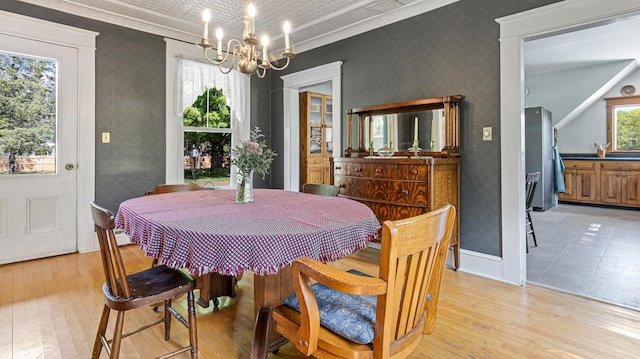 34 Mcphetres Rd, Sangerville, ME 04479 - dining room with wallpapered walls, a chandelier, light wood-type flooring, baseboards, and crown molding