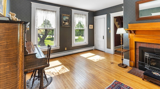 34 Mcphetres Rd, Sangerville, ME 04479 - living area with wallpapered walls, a baseboard heating unit, wood-type flooring, and baseboards