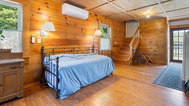34 Mcphetres Rd, Sangerville, ME 04479 - bedroom with light wood finished floors, an AC wall unit, wooden walls, and multiple windows
