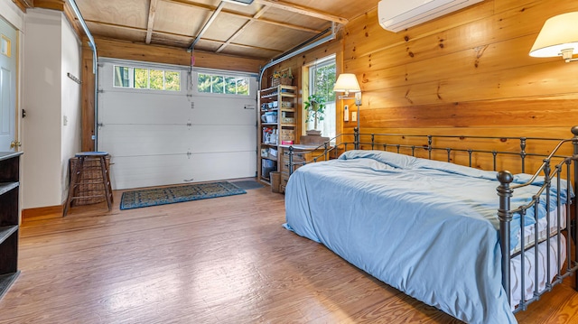 34 Mcphetres Rd, Sangerville, ME 04479 - bedroom with wood finished floors, wooden walls, a garage, and a wall unit AC