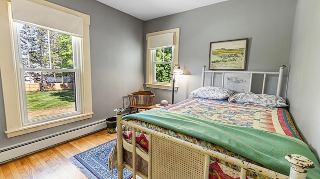 34 Mcphetres Rd, Sangerville, ME 04479 - bedroom featuring a baseboard radiator, multiple windows, and hardwood / wood-style floors
