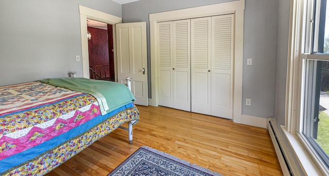 34 Mcphetres Rd, Sangerville, ME 04479 - bedroom with a baseboard radiator, light wood-style floors, a closet, and baseboards