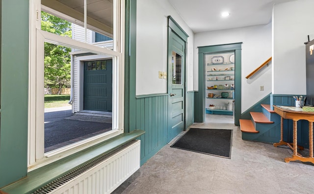 34 Mcphetres Rd, Sangerville, ME 04479 - foyer entrance with radiator heating unit, stairway, plenty of natural light, and wainscoting