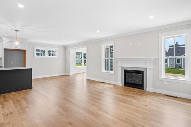 81 Creeks Edge Dr Unit 0, Saco, ME 04072 - unfurnished living room with ornamental molding, light wood finished floors, a glass covered fireplace, and recessed lighting