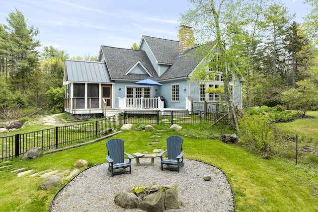 49 Moose Walk Rd, Westport Island, ME 04578 - back of house featuring roof with shingles, a sunroom, a deck, a chimney, and a patio