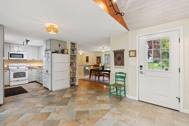 47 Woods Circle Rd, Yarmouth, ME 04096 - kitchen with white appliances, plenty of natural light, stone finish floors, vaulted ceiling, and light countertops