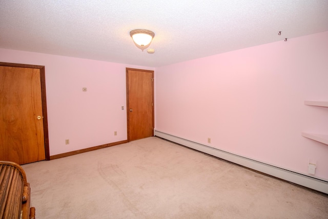 189 Stetson Rd E, Levant, ME 04456 - unfurnished bedroom featuring a baseboard heating unit, light colored carpet, and a textured ceiling