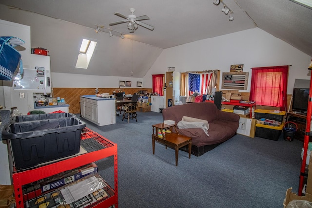 189 Stetson Rd E, Levant, ME 04456 - living room featuring rail lighting, vaulted ceiling, ceiling fan, carpet, and wood walls