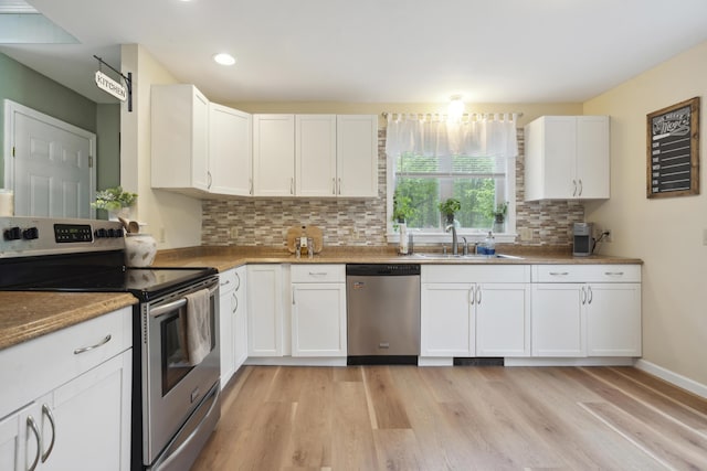 44 Emery Mills Rd, Lebanon, ME 04027 - kitchen with appliances with stainless steel finishes, a sink, light wood-type flooring, backsplash, and white cabinetry