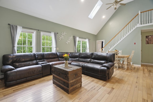 44 Emery Mills Rd, Lebanon, ME 04027 - living area featuring light wood-style floors, high vaulted ceiling, stairs, ceiling fan, and a skylight